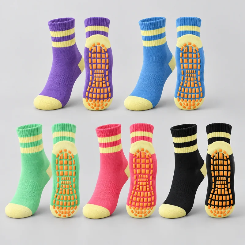 Purple, blue, mint, pink and black trampoline socks with yellow cuff stripes, heels and toes, shown from above and beneath with orange sole grip pads